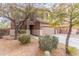 Exterior of a tan, two-story home with a two-car brown garage door and mature landscaping at 900 W Broadway Ave # 66, Apache Junction, AZ 85120