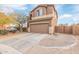 Two-story home featuring a neutral stucco exterior, a brown garage door, and a concrete driveway at 900 W Broadway Ave # 66, Apache Junction, AZ 85120