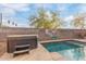 Backyard with a relaxing spa and street sign. Includes pool access and shade from a tree at 900 W Broadway Ave # 66, Apache Junction, AZ 85120