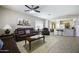 Relaxing living room featuring leather sofas, a ceiling fan, and bright shuttered windows at 9149 E Auburn St, Mesa, AZ 85207