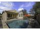 A gorgeous backyard pool features a rock waterfall feature and outdoor seating area at 9149 E Auburn St, Mesa, AZ 85207