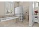 Beautiful bathroom featuring a soaking tub, glass block shower, and large window with shutters at 9161 W Bajada Rd, Peoria, AZ 85383