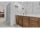 Well-lit bathroom featuring a wood vanity, shower with gray curtain, and a large mirror reflecting the clean space at 9161 W Bajada Rd, Peoria, AZ 85383