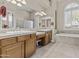 Bright bathroom featuring dual sinks, built-in vanity, soaking tub, and large windows at 9161 W Bajada Rd, Peoria, AZ 85383