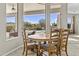 Bright dining area showcasing backyard views of the pool, desert landscaping, and rock slide feature at 9161 W Bajada Rd, Peoria, AZ 85383