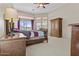 Bright main bedroom featuring large windows, a ceiling fan, and dark wood furniture at 9161 W Bajada Rd, Peoria, AZ 85383