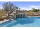 Beautiful backyard pool featuring a rock waterfall and lush landscaping at 9161 W Bajada Rd, Peoria, AZ 85383