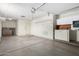 View of an empty garage featuring cement floors, a garage door, and white cabinets for storage at 9614 W Pleasant Valley Rd, Sun City, AZ 85351