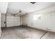 View of an empty garage featuring cement floors, a garage door, and a window at 9614 W Pleasant Valley Rd, Sun City, AZ 85351