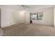 Neutral living room features a large window, carpet, and a ceiling fan at 9614 W Pleasant Valley Rd, Sun City, AZ 85351