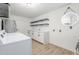 A well-lit laundry room with floating shelves, cabinets, and a large mirror at 11026 W Bluefield Ct, Sun City, AZ 85351