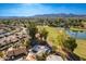 An aerial view of the community, home, and a golf course with a pond, backing up to mountain views at 11612 S 51St St, Phoenix, AZ 85044
