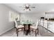 Bright dining area features a glass table, white chairs, and views to the kitchen bar at 11612 S 51St St, Phoenix, AZ 85044