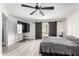 Large bedroom with dark wood sliding barn door, ceiling fan, and plush bedding at 11612 S 51St St, Phoenix, AZ 85044
