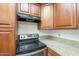 Close-up of kitchen with wooden cabinets, granite counters, and stainless steel appliances at 11666 N 28Th Dr # 196, Phoenix, AZ 85029