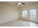 Well-lit living room with light wood-look floors, a ceiling fan, and a door to the outside at 11666 N 28Th Dr # 196, Phoenix, AZ 85029