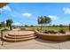 Tiered back patio boasting stone steps, a tranquil waterfall, and views of the lush golf course at 15751 W Linksview Dr, Surprise, AZ 85374