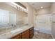 Bathroom showcasing granite countertops, framed mirrors, and a well-lit vanity offers style and functionality at 15751 W Linksview Dr, Surprise, AZ 85374