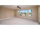 Spacious carpeted bedroom with ceiling fan and views of the desert landscape and golf course at 15751 W Linksview Dr, Surprise, AZ 85374