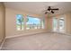 Large carpeted bedroom featuring desert landscape and golf course views and access to the patio at 15751 W Linksview Dr, Surprise, AZ 85374