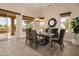 Elegant dining room with a table set for six, a decorative mirror, and views of the backyard at 15751 W Linksview Dr, Surprise, AZ 85374