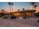 Charming home exterior with well-maintained desert landscaping, lush plants, and tranquil backyard setting at 15751 W Linksview Dr, Surprise, AZ 85374