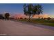 Beautiful golf course view, highlighting manicured greens, mature trees, and the colorful twilight sky at 15751 W Linksview Dr, Surprise, AZ 85374