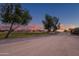 Scenic view of the golf course landscape with mature trees, vibrant sunset colors, and green fairways at 15751 W Linksview Dr, Surprise, AZ 85374