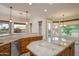 Open kitchen featuring granite counters, tile floors, view of backyard landscaping and outdoor dining space at 15751 W Linksview Dr, Surprise, AZ 85374