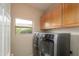 Laundry room featuring modern washer and dryer units and cabinets for convenient storage at 15751 W Linksview Dr, Surprise, AZ 85374