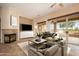 Cozy living room with a fireplace, comfortable seating, and a large sliding glass door to the backyard at 15751 W Linksview Dr, Surprise, AZ 85374