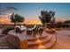 Cozy outdoor patio seating area overlooking the beautiful golf course and picturesque sunset view at 15751 W Linksview Dr, Surprise, AZ 85374