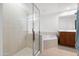 Bathroom featuring a walk-in glass shower, soaking tub, and a wood vanity with and sinks at 16 W Encanto Blvd # 616, Phoenix, AZ 85003