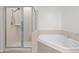 Bright bathroom featuring a large soaking tub, and a glass enclosed shower with white tile at 16 W Encanto Blvd # 616, Phoenix, AZ 85003