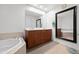 Bathroom featuring double sinks, a soaking tub, a large mirror, and warm lighting at 16 W Encanto Blvd # 616, Phoenix, AZ 85003