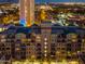 Exterior shot of a modern condominium building at dusk, showcasing multiple balconies and illuminated windows at 16 W Encanto Blvd # 616, Phoenix, AZ 85003