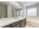 Modern bathroom features a dual vanity, soaking tub, separate shower, and abundant natural light at 16167 W Cottonwood St, Surprise, AZ 85374