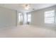 Expansive primary bedroom with neutral carpet, ceiling fan, archway to bathroom, and multiple windows for natural light at 16167 W Cottonwood St, Surprise, AZ 85374