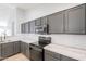 Gray cabinets with stainless appliances and hardware accent this kitchen's counterspace and subway tile backsplash at 16167 W Cottonwood St, Surprise, AZ 85374