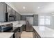 This kitchen features stainless steel appliances, gray cabinets with gold hardware, and a center island at 16167 W Cottonwood St, Surprise, AZ 85374
