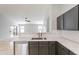 A kitchen includes stainless steel appliances and gold hardware, open to the living room with a ceiling fan at 16167 W Cottonwood St, Surprise, AZ 85374