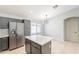 A stainless steel refrigerator and center island accent this kitchen with its gray cabinets and white countertops at 16167 W Cottonwood St, Surprise, AZ 85374