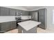 A stainless steel refrigerator and center island enhance this gray kitchen with white countertops and backsplash at 16167 W Cottonwood St, Surprise, AZ 85374