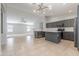Modern kitchen features stainless steel appliances, island, gray cabinets, tile backsplash, and open layout to living room at 16167 W Cottonwood St, Surprise, AZ 85374
