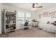 Bright bedroom featuring a ceiling fan, a large bookcase, and a workstation with natural light from the window at 18449 E Eloisa Dr, Gold Canyon, AZ 85118