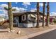 Inviting home exterior with desert landscaping, featuring palm trees and a large cactus at 201 S Greenfield Rd # 152, Mesa, AZ 85206