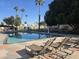 Community pool featuring lounge chairs, well-maintained landscaping, and a pool lift for accessibility at 201 S Greenfield Rd # 152, Mesa, AZ 85206