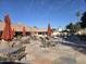 Community pool area featuring lounge chairs, tables with umbrellas, and well-maintained landscaping at 201 S Greenfield Rd # 152, Mesa, AZ 85206