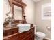 Charming powder room featuring a unique vanity, vessel sink, and a decorative mirror at 21417 N 142Nd Dr, Sun City West, AZ 85375