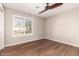 This bedroom features wood floors, a ceiling fan, and a window with plantation shutters at 21417 N 142Nd Dr, Sun City West, AZ 85375